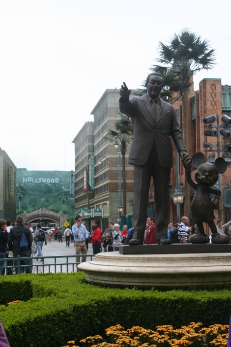 Walt Disney, holding Mickey Mouse's hand